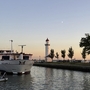 Schiff im Hafen von Hellevoetsluis bei Sonnenuntergang mit Leuchtturm im Hintergrund.