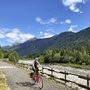 Radfahrer auf dem Alpe-Adria-Radweg in bergiger Landschaft bei sonnigem Wetter.