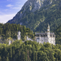 Schloss Neuschwanstein in Bayern, umgeben von Wald und Bergen.