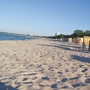 Sandstrand mit Strandkörben und Meerblick unter klarem Himmel.