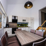 Moderne Küche mit Esstisch, Stühlen und Treppe in einem hellen Raum.
