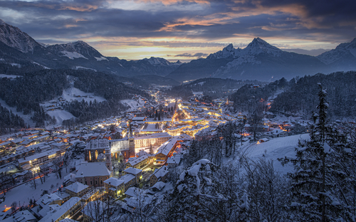 Winterliches Panorama von Berchtesgaden bei Sonnenuntergang mit verschneiten Bergen.