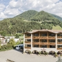 Hotel Alpenrose vor einer bewaldeten Berglandschaft bei St. Lorenzen.