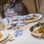 Ein gedeckter Tisch mit Wein und servierten Gerichten in einem Restaurant.