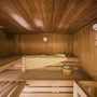 Innenansicht einer Holzsauna mit Handtuch und Saunaeimer.