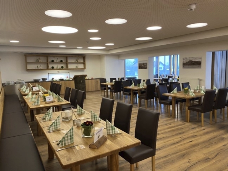 Ein moderner Speiseraum mit gedeckten Tischen und Holzfußboden.