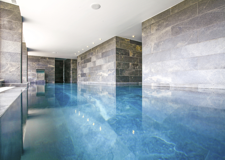 Innenpool im Hotel mit modernen Steinwänden und klarem Wasser.