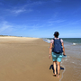 Person wandert allein am Strand von Ilha de Tavira, Algarve, Portugal.
