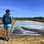 Person betrachtet Salzbecken in Fuseta, Algarve, bei klarem Himmel.