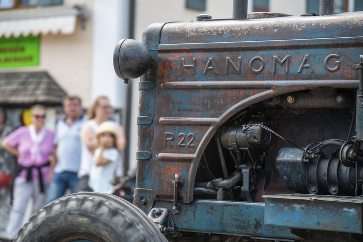 Oldtimer-Traktor bei einem Treffen in Inzell, Zuschauer im Hintergrund.