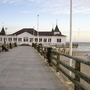 Seebrücke mit Haus am Strand von Ahlbeck bei Sonnenuntergang.
