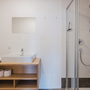 Modernes Badezimmer mit Waschbecken, Spiegel und Dusche.