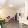 Wohnzimmer mit Kamin, Stühlen, Tisch und Küche in Braunlage.