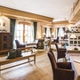 Gemütliches Restaurant mit Holzeinrichtung und gedeckten Tischen im Schlosshotel Kitzbühel.