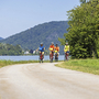 Gruppe von Radfahrern auf dem Donau-Radweg bei sonnigem Wetter.