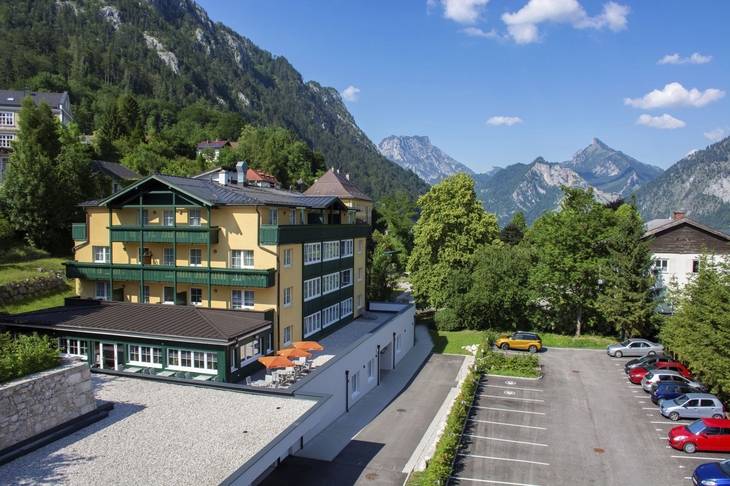 Außenansicht des Landhotels Post Ebensee in bergiger Landschaft.