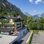 Außenansicht des Landhotels Post Ebensee in bergiger Landschaft.