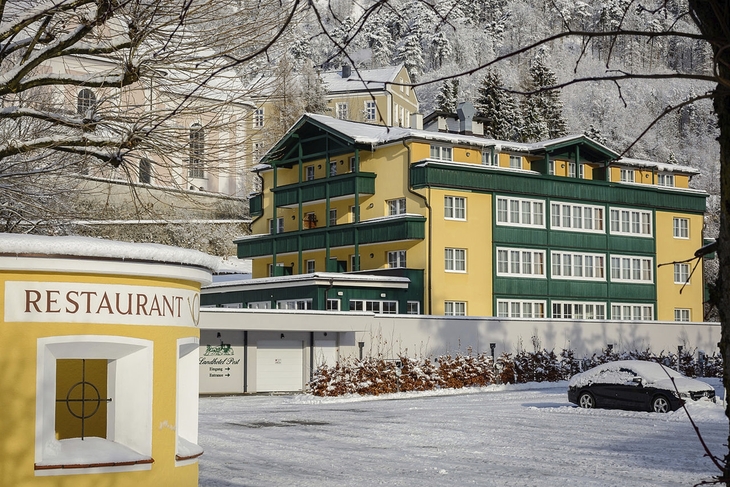 Landhotel Post Ebensee im Winter mit Schnee bedeckt, Außenansicht.