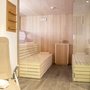 Saunabereich mit hölzernen Bänken und Glaswänden im Wellnessbereich eines Hotels.