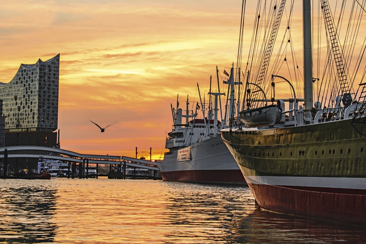 Hafen von Hamburg im Sonnenuntergang mit Schiffen und Elbphilharmonie.