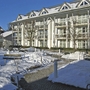 Mehrstöckiges Gebäude im Winter mit verschneitem Garten.