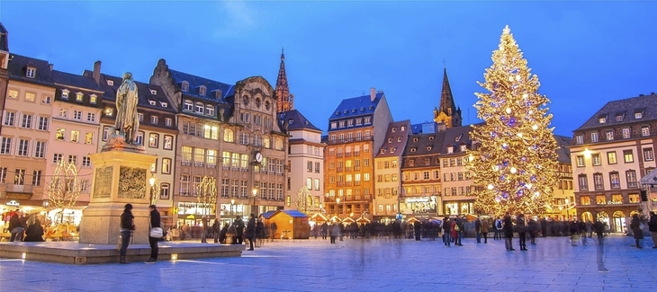 Straßburger Weihnachtsmarkt mit beleuchtetem Weihnachtsbaum und historischen Gebäuden.
