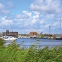 Hafen von Harlesiel mit Segelbooten und bewölktem Himmel im Hintergrund.