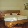 Schlafzimmer mit Doppelbett, Nachttisch und Sonnenblumenbild an der Wand in Ferienanlage Harlesiel.