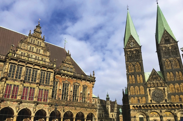 Historische Gebäude am Marktplatz in Bremen mit Kirchenfassaden bei klarem Himmel.