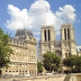 Gebäudeansicht mit Notre-Dame-Kathedrale und blauem Himmel im Hintergrund.