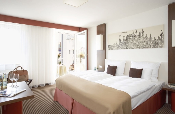 Doppelzimmer mit Doppelbett, hellem Dekor und großen Fenstern im Best Western Hotel Nürnberg.