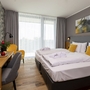 Hotelzimmer mit Doppelbett, Schreibtisch und moderner Einrichtung.