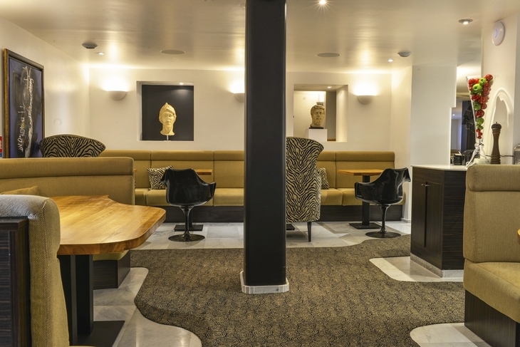 Modern eingerichtetes Hotelrestaurant mit Sitznischen und Kunst an den Wänden.