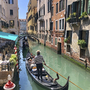 Gondel auf einem Kanal in Venedig mit umliegenden Gebäuden und Café.