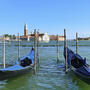 Zwei Gondeln auf einem Kanal mit Kirche im Hintergrund in Venedig.