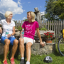Zwei Frauen machen eine Radlerpause an einem Brunnen auf dem Tauernradweg.