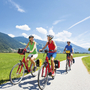 Radfahrer auf dem Tauernradweg in einer grünen Landschaft bei sonnigem Wetter.