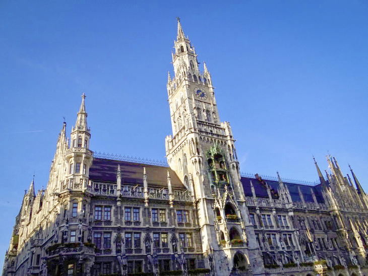 Münchens Neues Rathaus bei Tageslicht vor blauem Himmel.