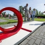 Kind spielt Minigolf mit Looping in der Ferienanlage Prüm. Ein anderes Kind und die Eltern schauen zu