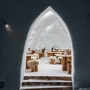 Eingang zu einem Iglu-Restaurant mit Holztischen und Fell bedeckten Stühlen.