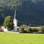 Kirche im Grünen vor bewaldeten Bergen im Ort Oberwössen.