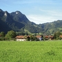 Landschaft von Oberwössen mit Bergen und Wiesen im Hintergrund.