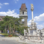 Blick auf den historischen Turm und eine barocke Säule auf dem Platz in Perchtoldsdorf.
