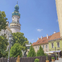 Feuerwachturm in Sopron vor blauem Himmel und umliegenden Gebäuden.