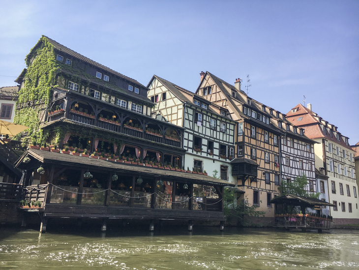Fachwerkhäuser am Fluss in Straßburg bei klarem Himmel.