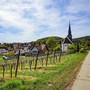 Radweg in Rechtenbach mit Kirche und Weinbergen im Hintergrund.