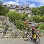 Radfahrer vor historischem Schloss mit Garten in Truyes, Loire.