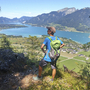 Person beim Wandern mit Blick auf den Wolfgangsee und die umliegenden Berge.