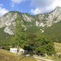 Berglandschaft in Friaul mit Wiesen, Bäumen und einem Wanderweg im Vordergrund
