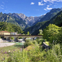 Brücke über Fluss vor Bergpanorama in den Alpen in Friaul, Italien.